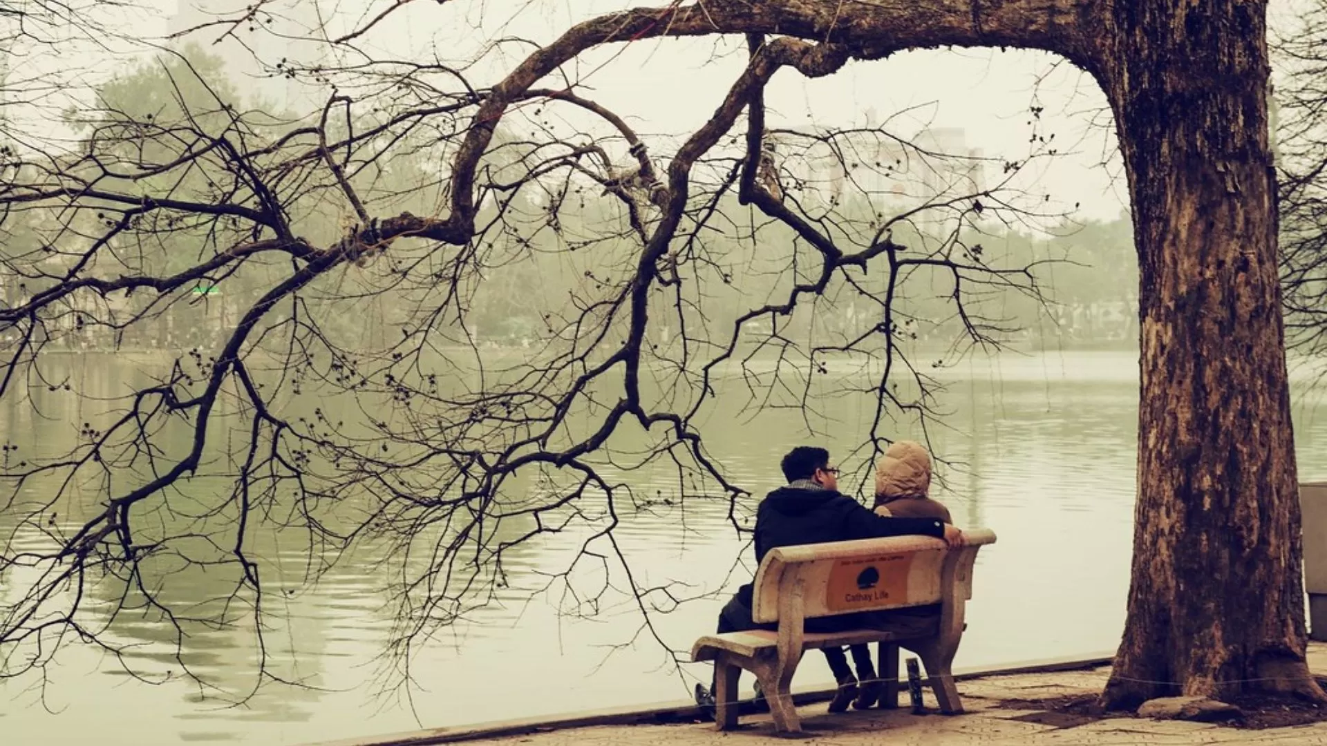 Couples sitting around Hoan Kiem Lake, enjoying the chilly atmosphere.